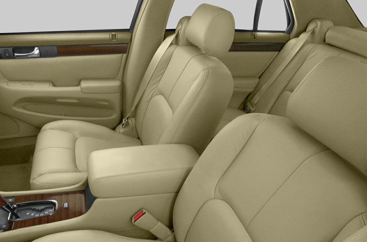 Beige leather seats and wood trim interior with armrest and gear shift