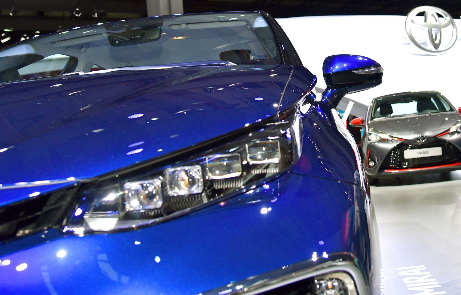 Close-up of front LED headlight and side mirror on a blue vehicle
