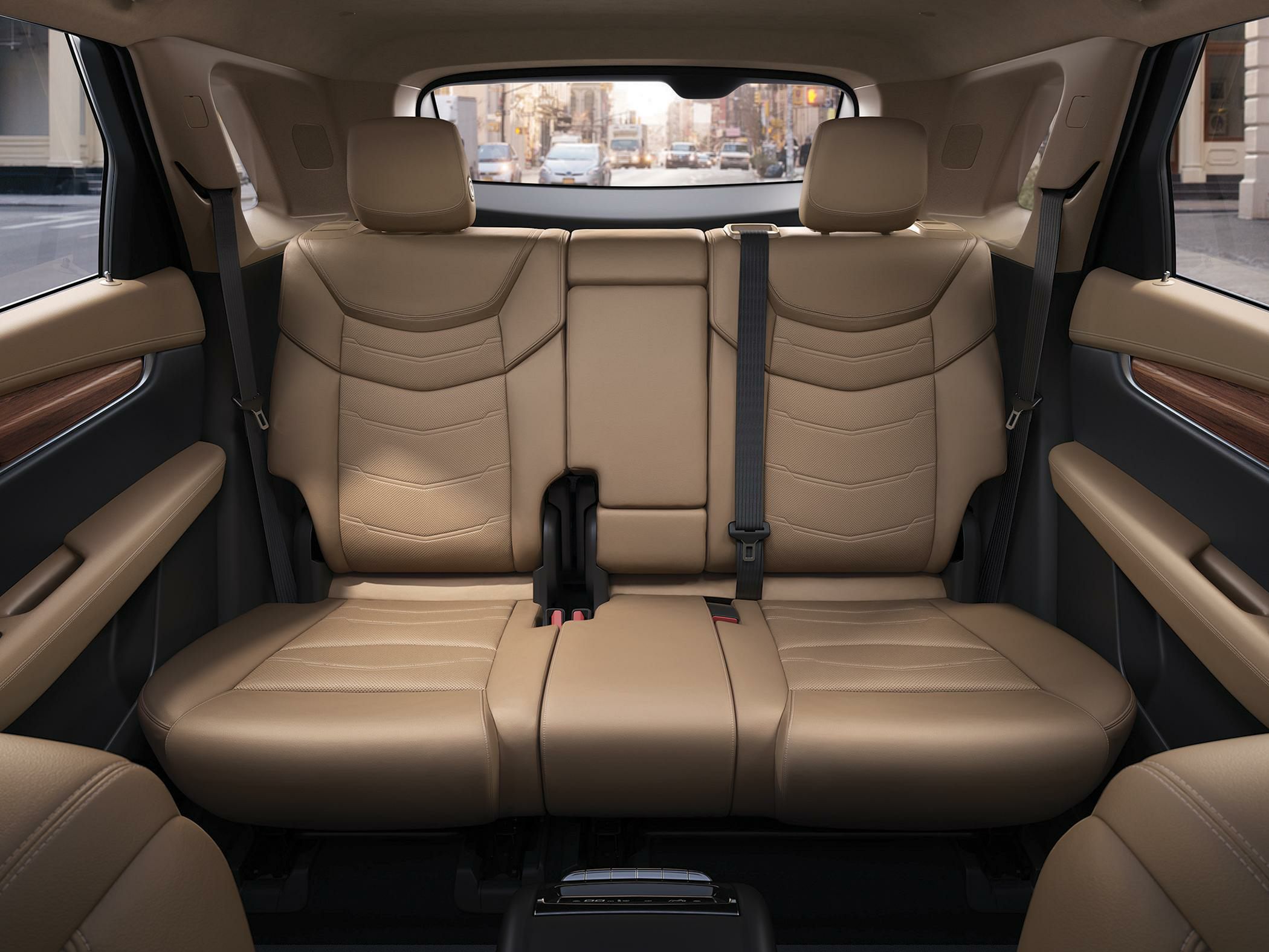 Beige leather rear seats with seat belts and urban street view