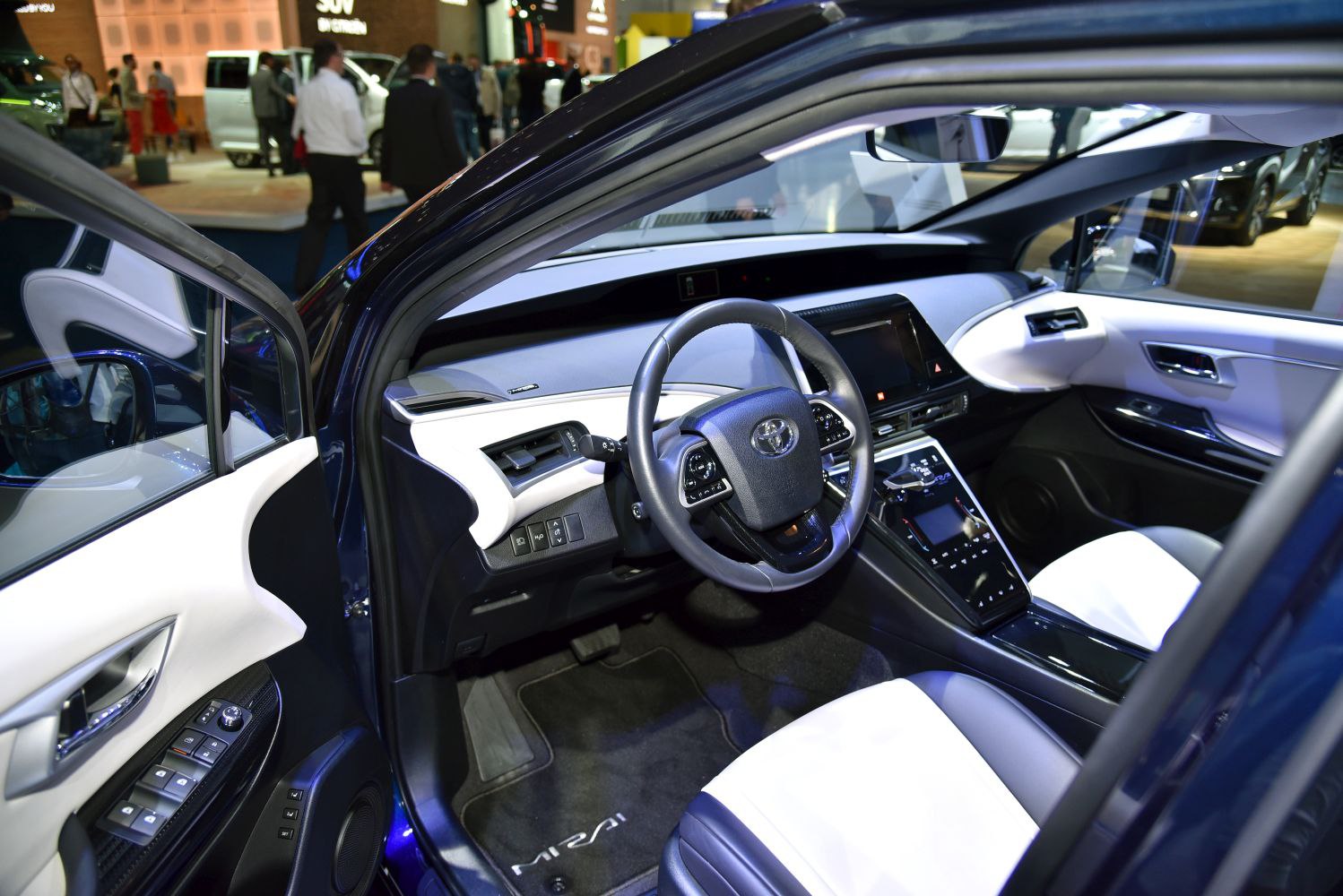 Interior with steering wheel, dashboard, center console, and white seats