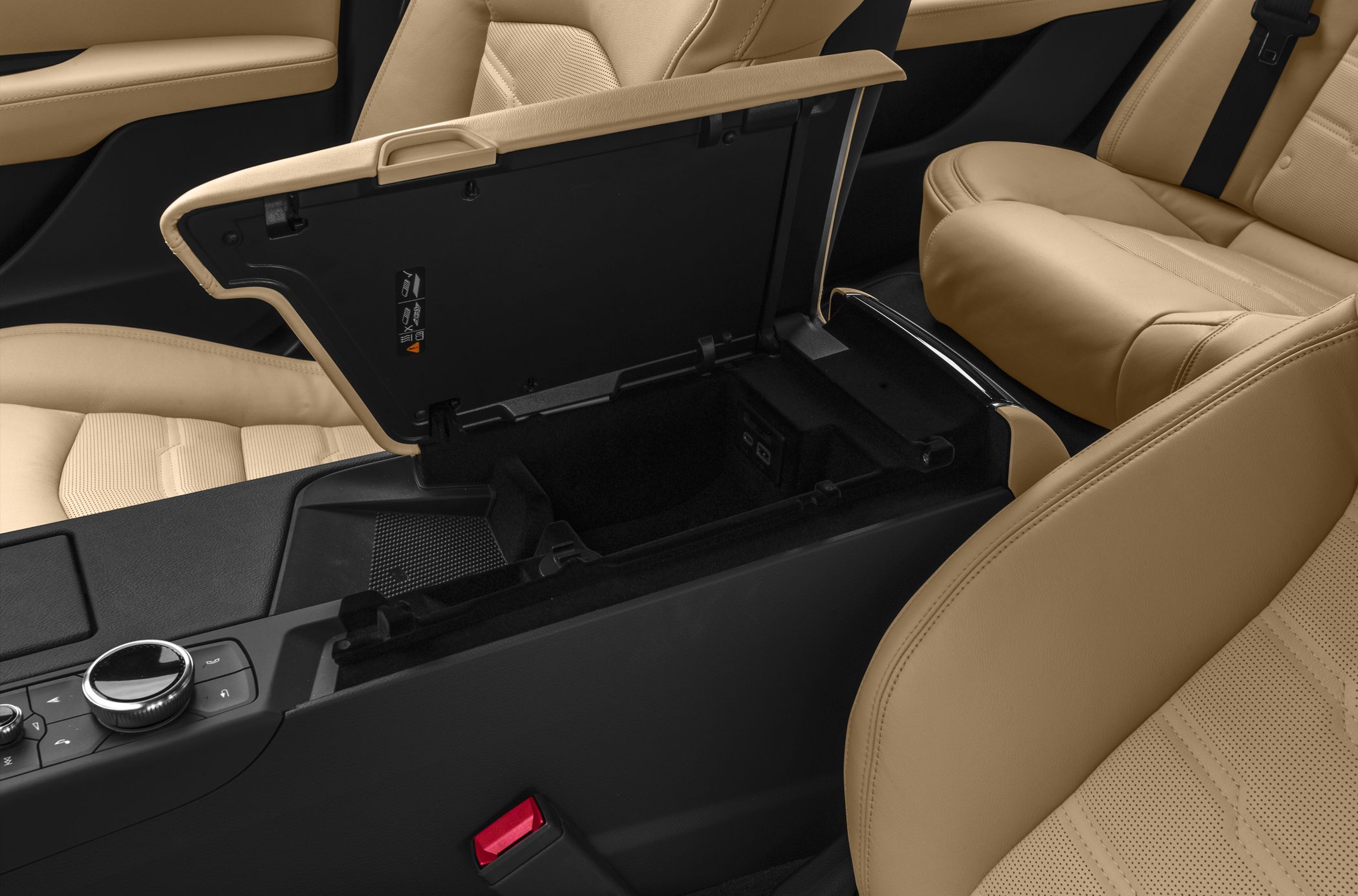 Open center console storage with control knobs and beige leather seats