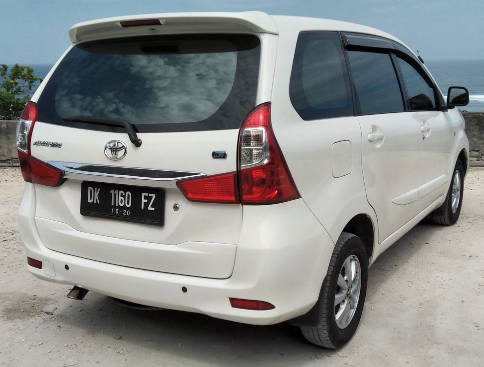 Rear view of white MPV with distinctive taillights and rear windshield wiper.