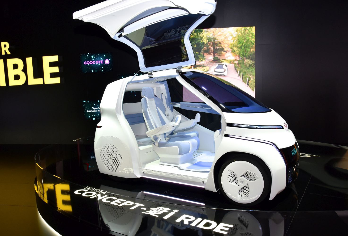 Futuristic electric concept vehicle with gullwing doors and innovative spacious interior seating.