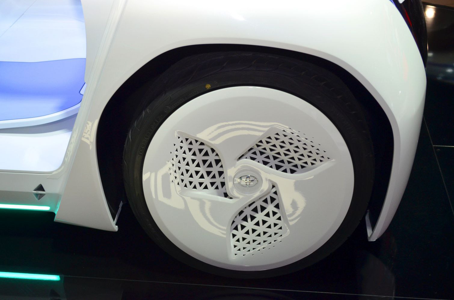 Futuristic aerodynamic wheel cover with geometric ventilation pattern.