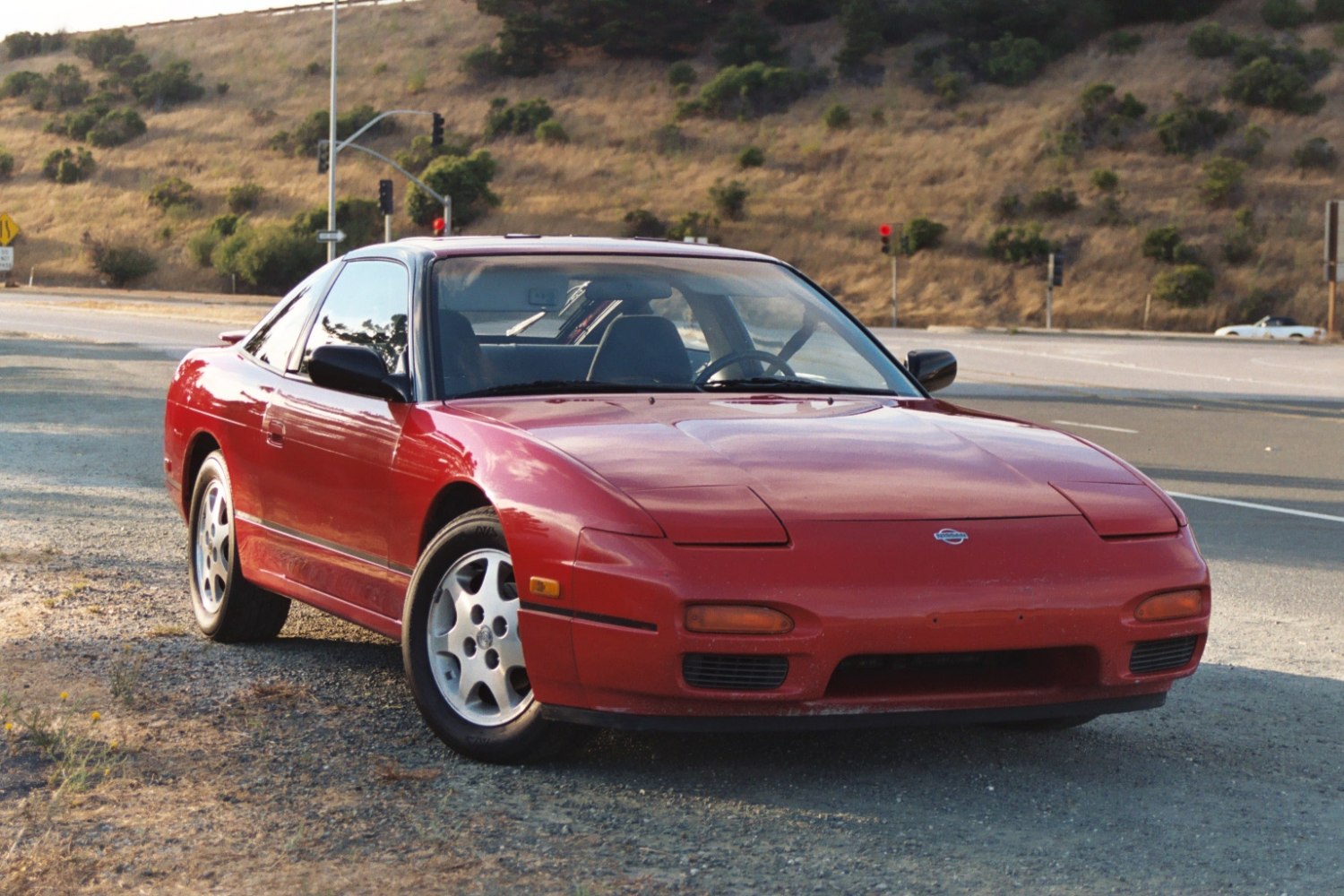 Red sporty coupe with pop-up headlights and fastback design.