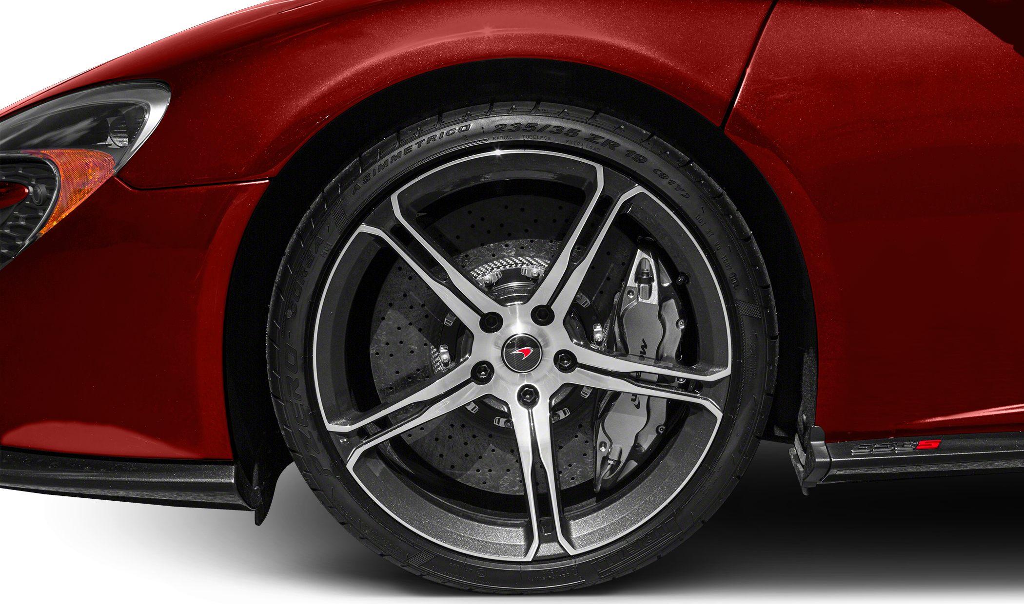 Alloy wheel with ventilated brake disc and caliper on red sports car.