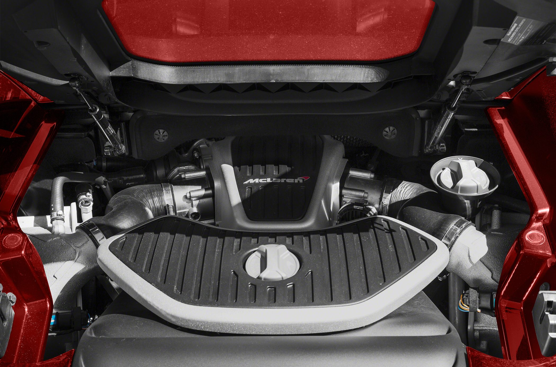 Close-up of a V8 engine bay with detailed components and McLaren branding