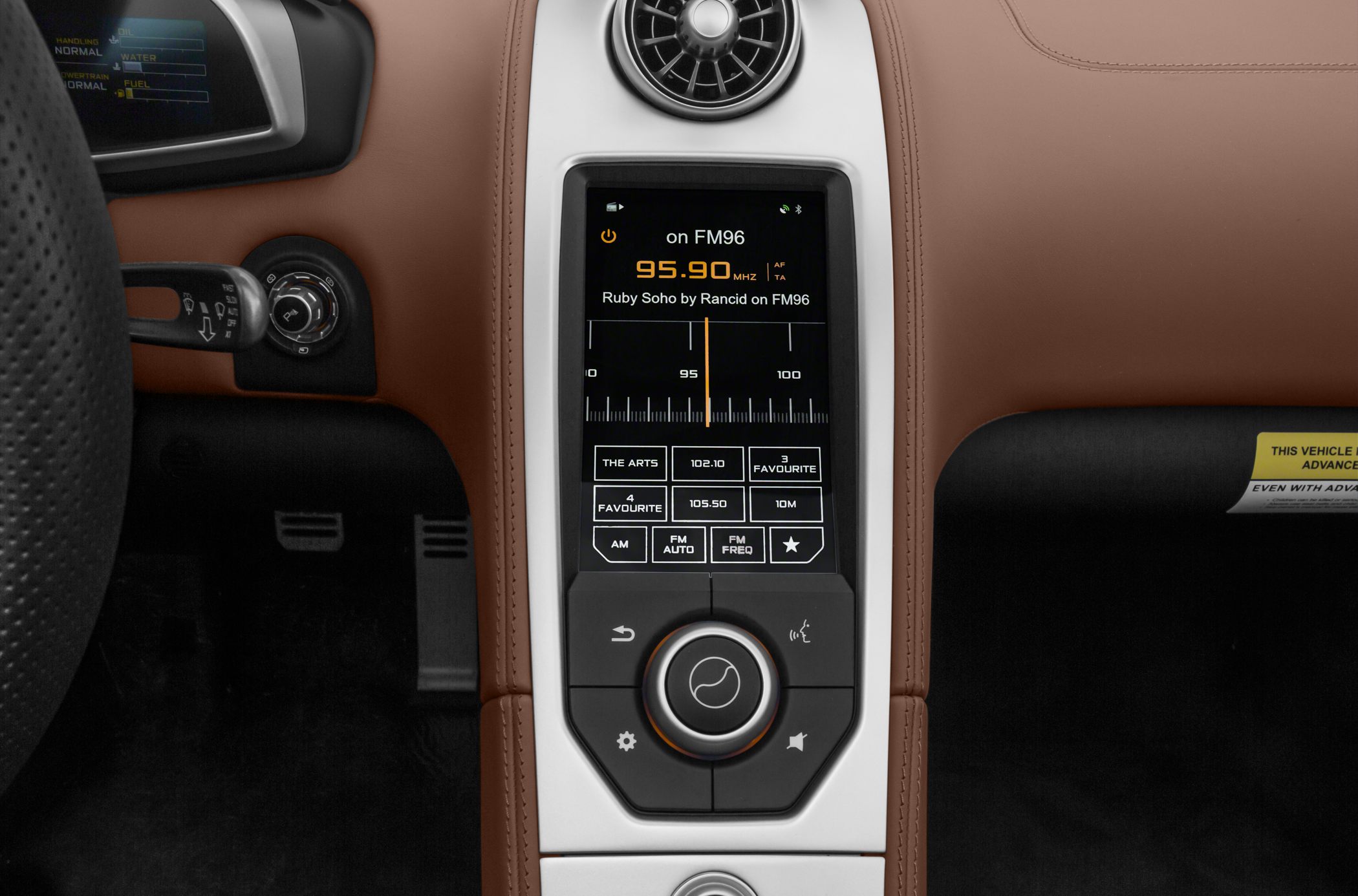 Center console infotainment touchscreen and circular air vent in brown interior