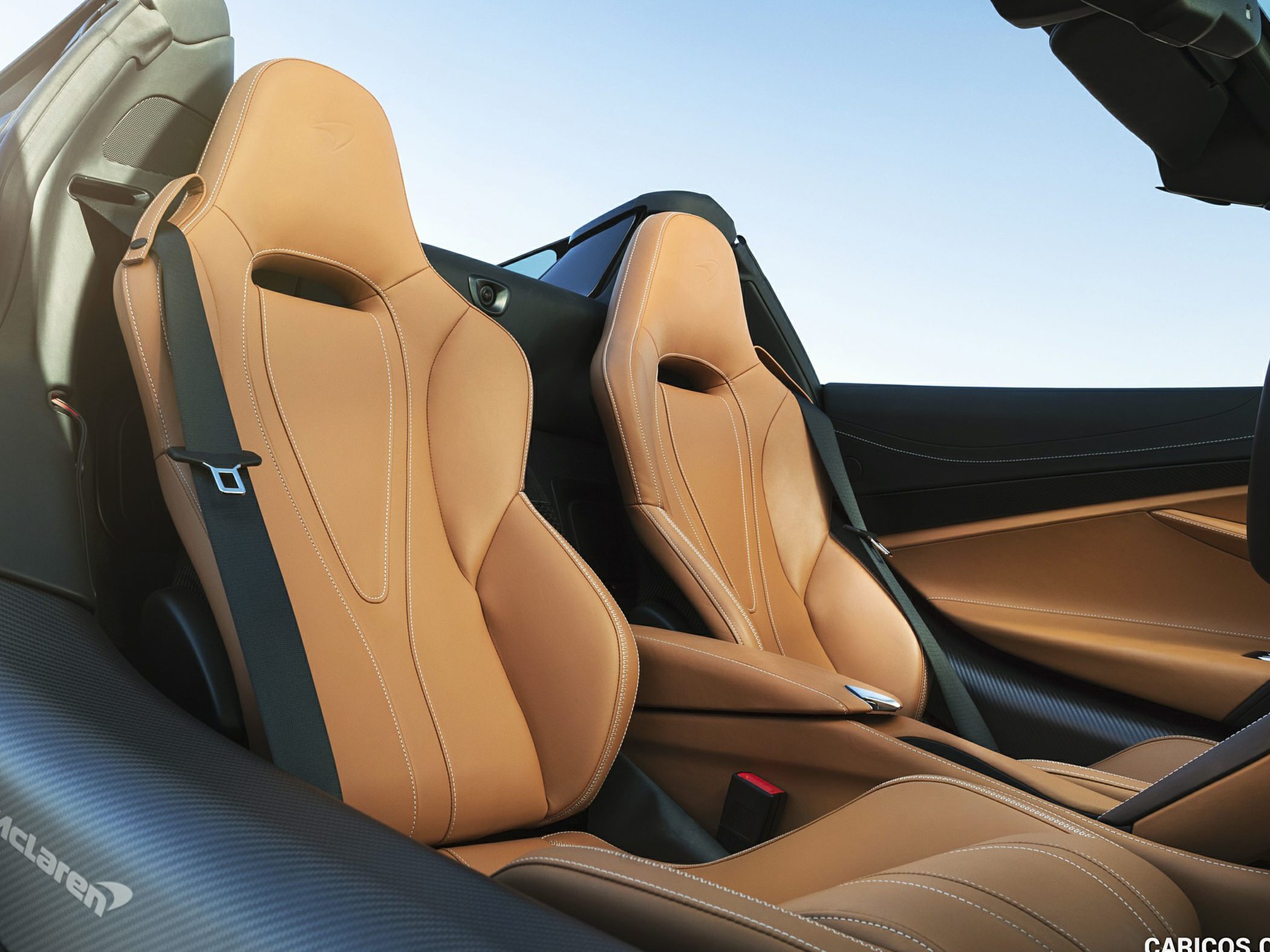 Tan leather sports seats with detailed stitching and carbon fiber trim
