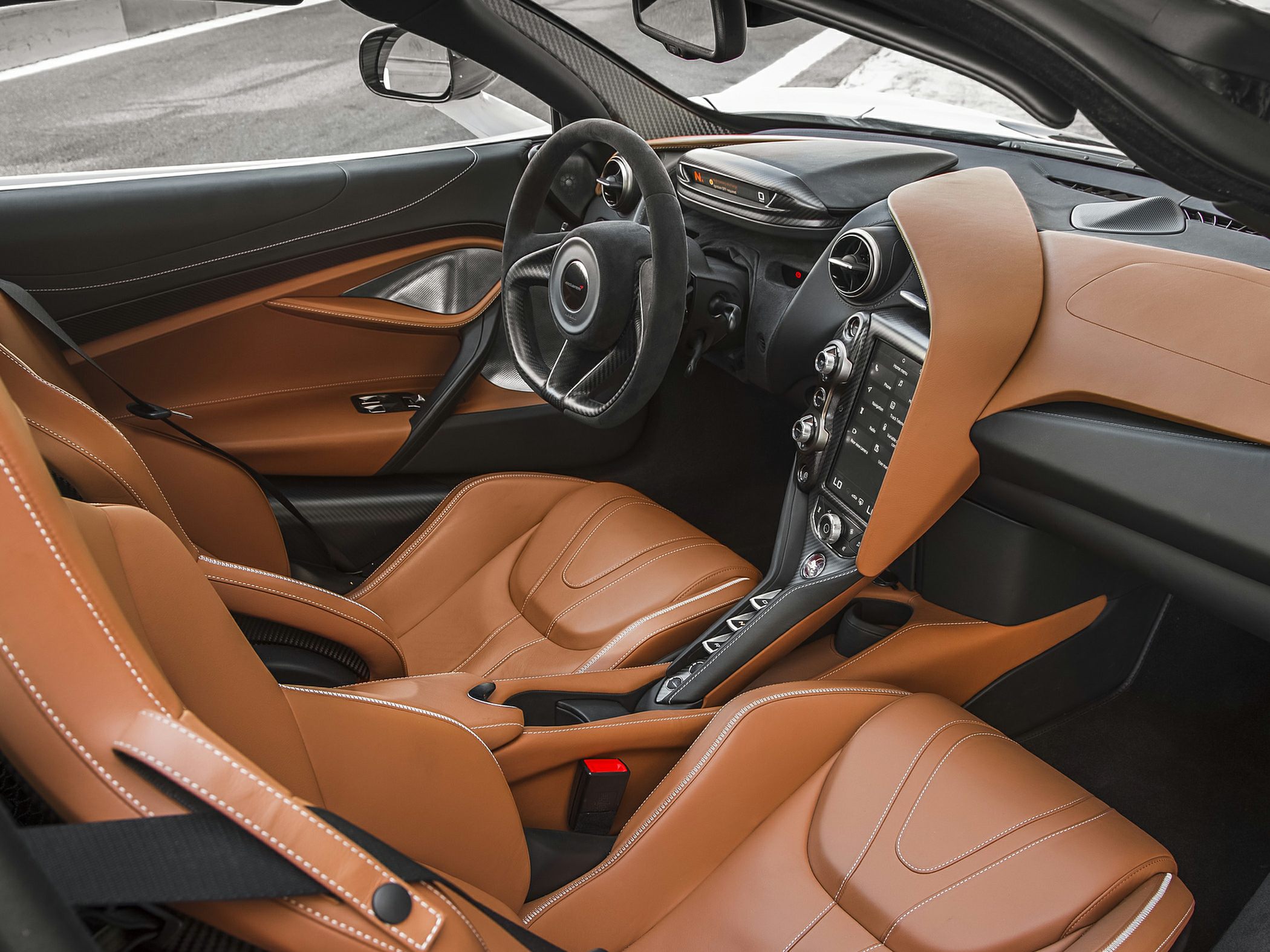 Luxury brown leather and carbon fiber interior with advanced controls.