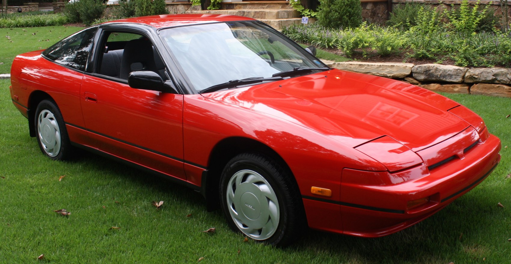 Red sports coupe with pop-up headlights and sleek fastback design