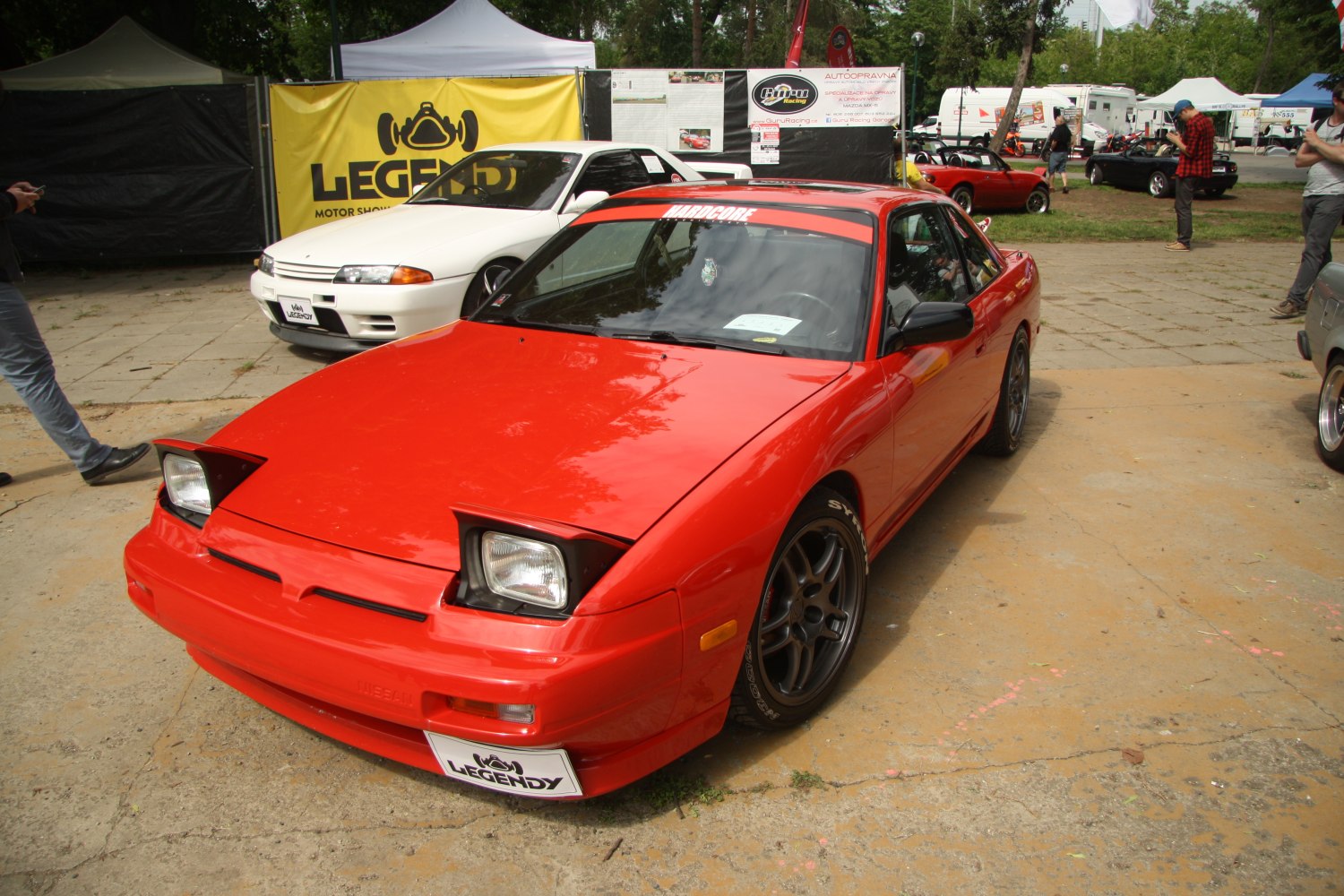 Red fastback coupe with pop-up headlights and aftermarket wheels