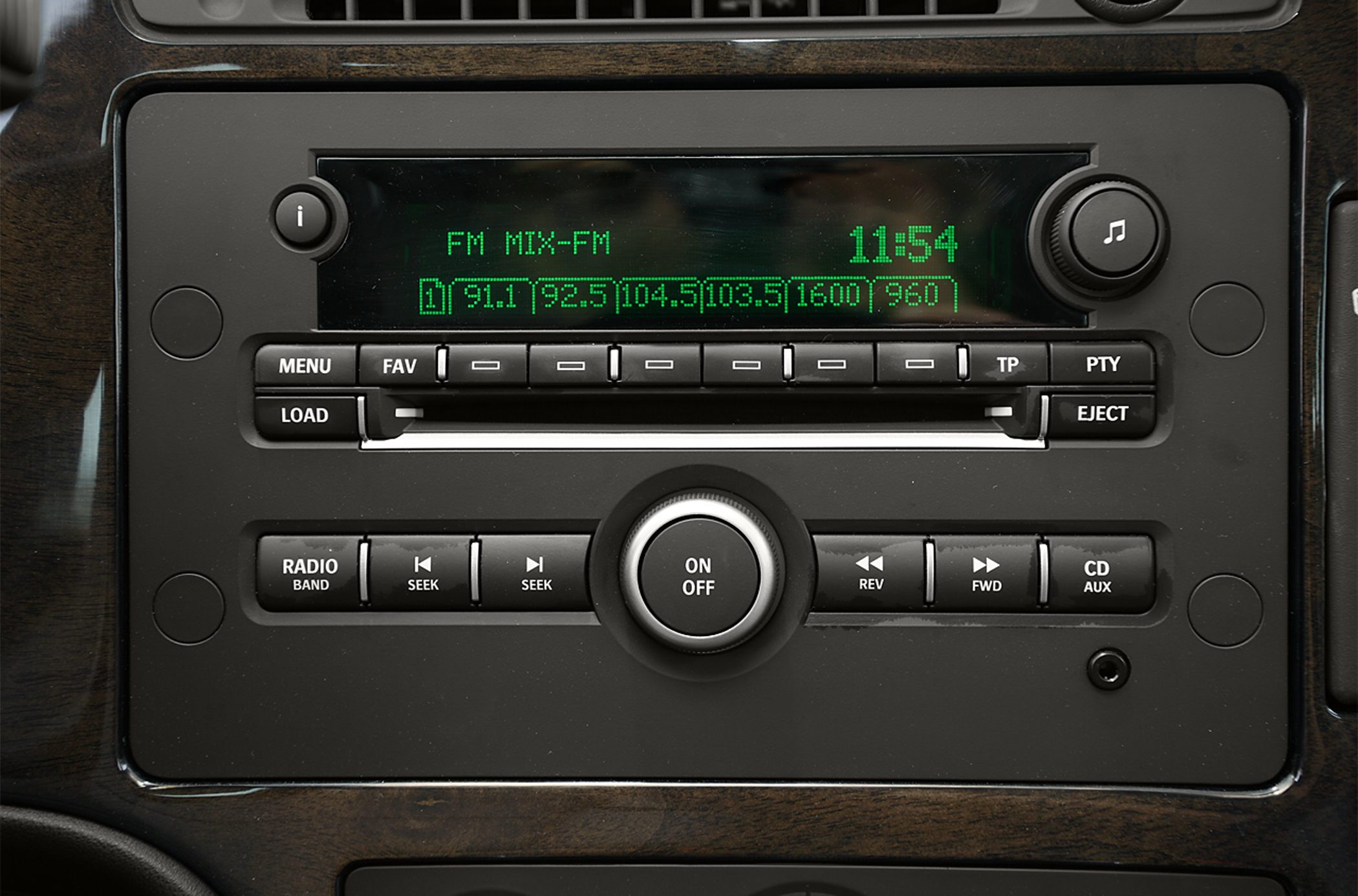 Car radio console with FM display, control buttons, and wood trim panel