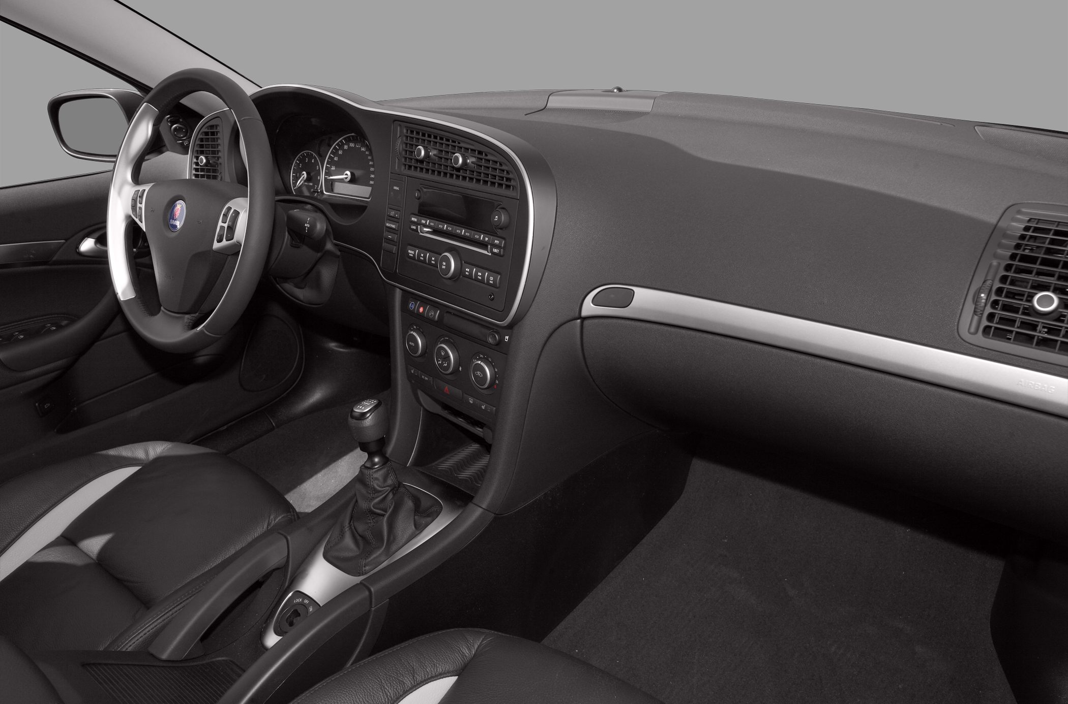 Car interior with manual gear shift, leather seats, and dashboard controls