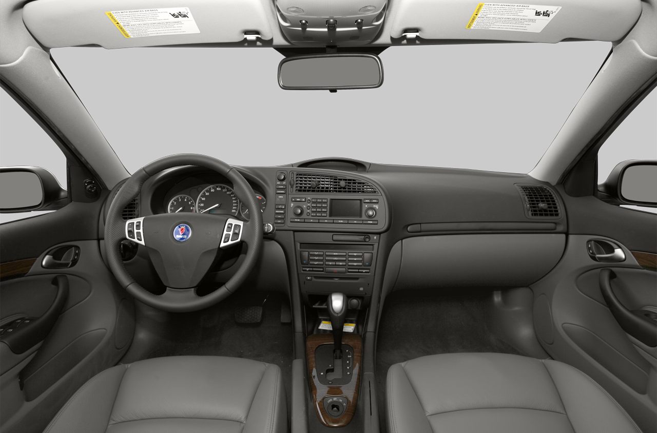Dashboard layout with steering wheel and center console featuring wood trim