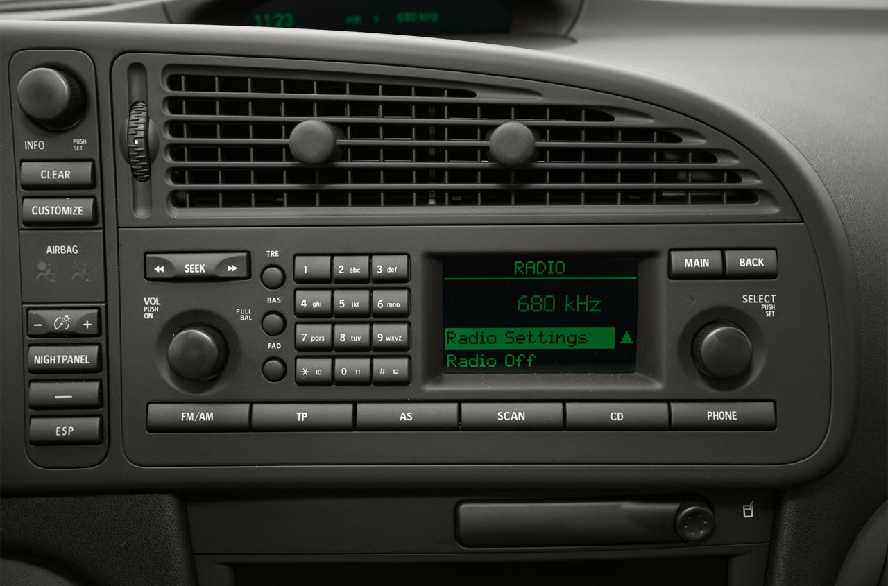 Vintage car radio and climate control dashboard panel with button controls and digital display.