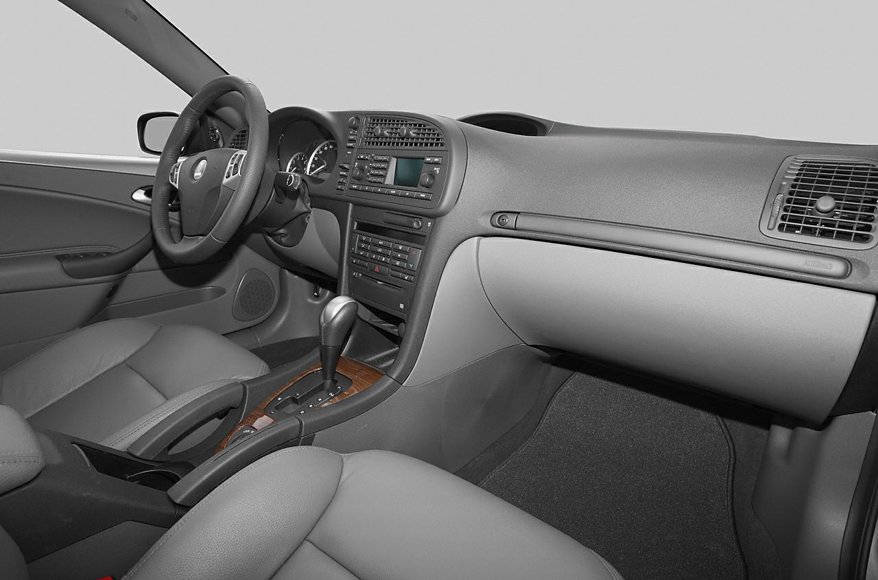 Interior dashboard and gear console with steering wheel and seats.