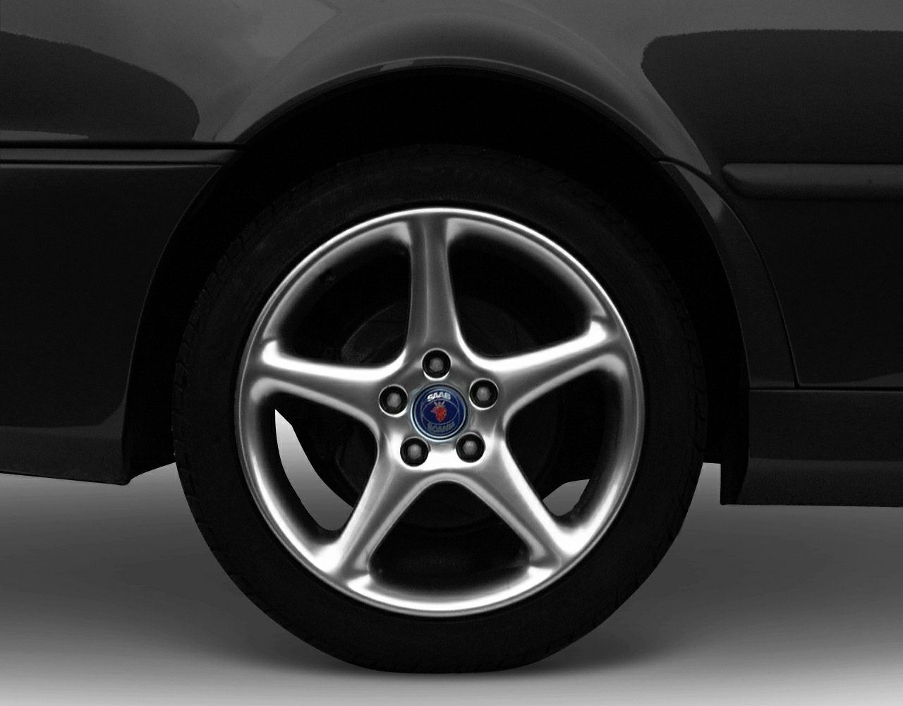 Close-up of a five-spoke silver alloy wheel with Saab emblem center cap