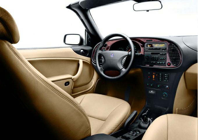 Beige leather seats and dashboard with steering wheel and center console.