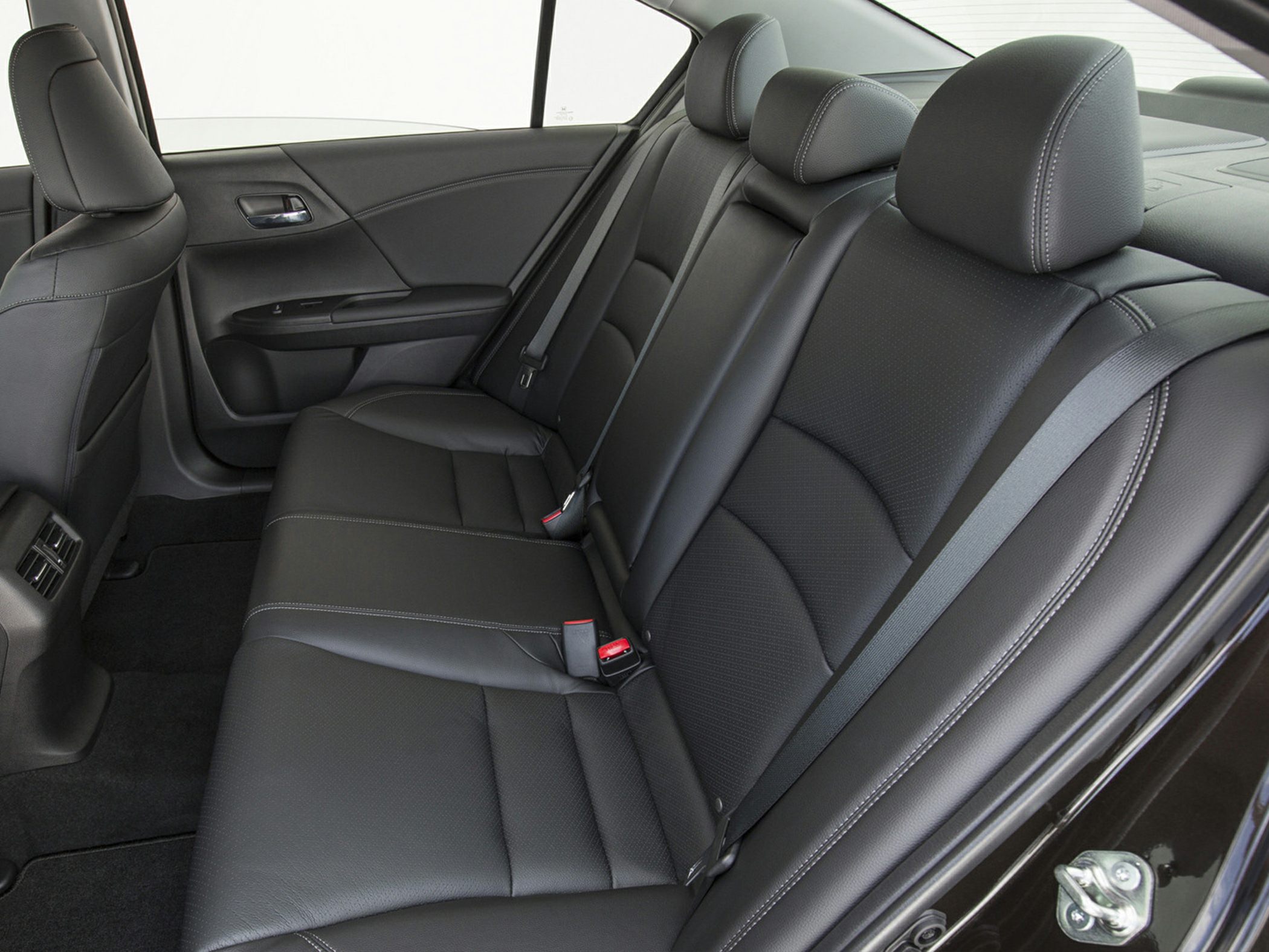 Rear seat with black leather upholstery and modern seatbelt design