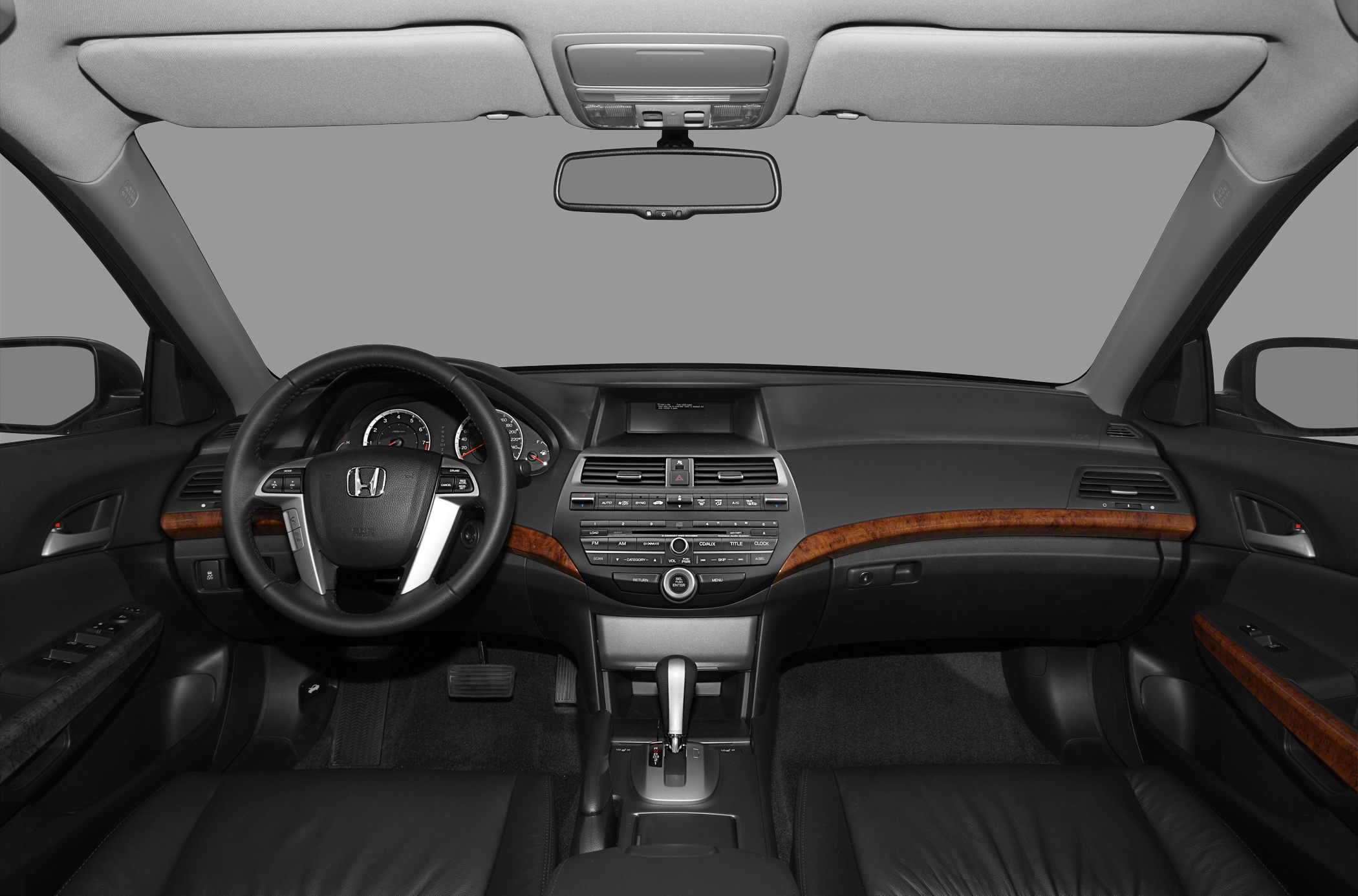 Car interior with dashboard, steering wheel, wood trim, gear shift