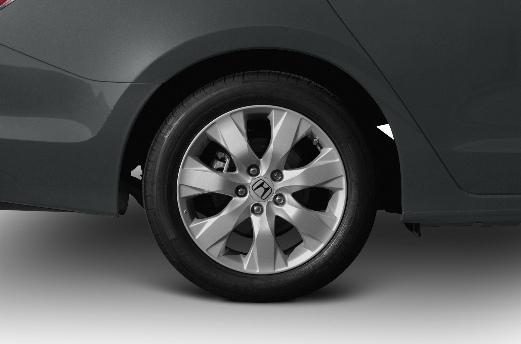 Close-up of multi-spoke alloy wheel and tire on vehicle.
