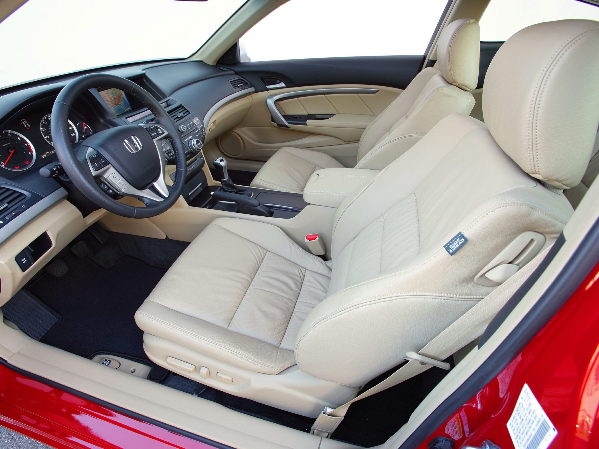 Beige leather seats and manual transmission inside a coupe.