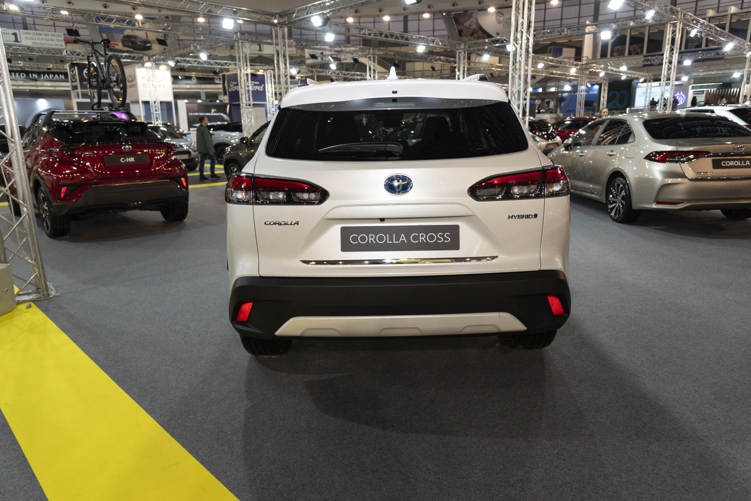 Rear view of a white hybrid crossover with distinct tail lights and rear bumper