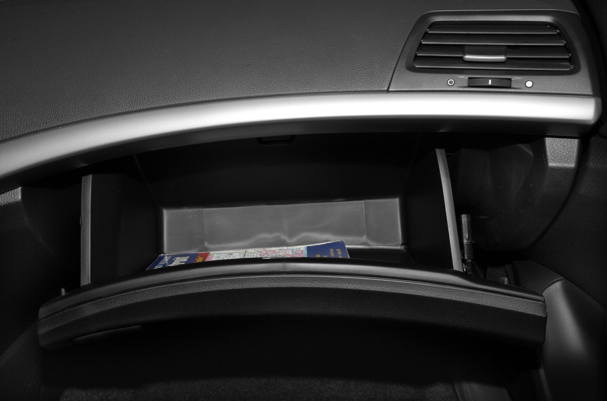 Open glove compartment and dashboard air vent interior view