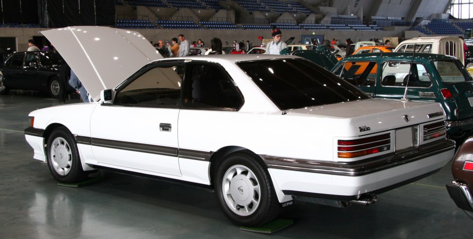 White two-door coupe with open hood, side and rear view.