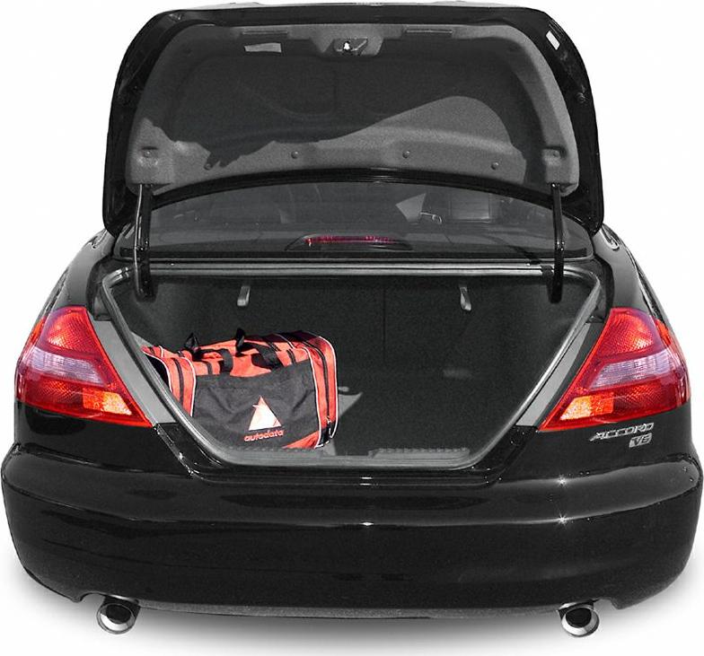 Open car trunk with a packed bag inside and visible dual exhausts