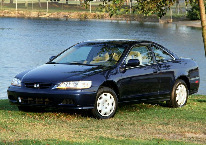Sleek front side view of a 1998 coupe near a lake