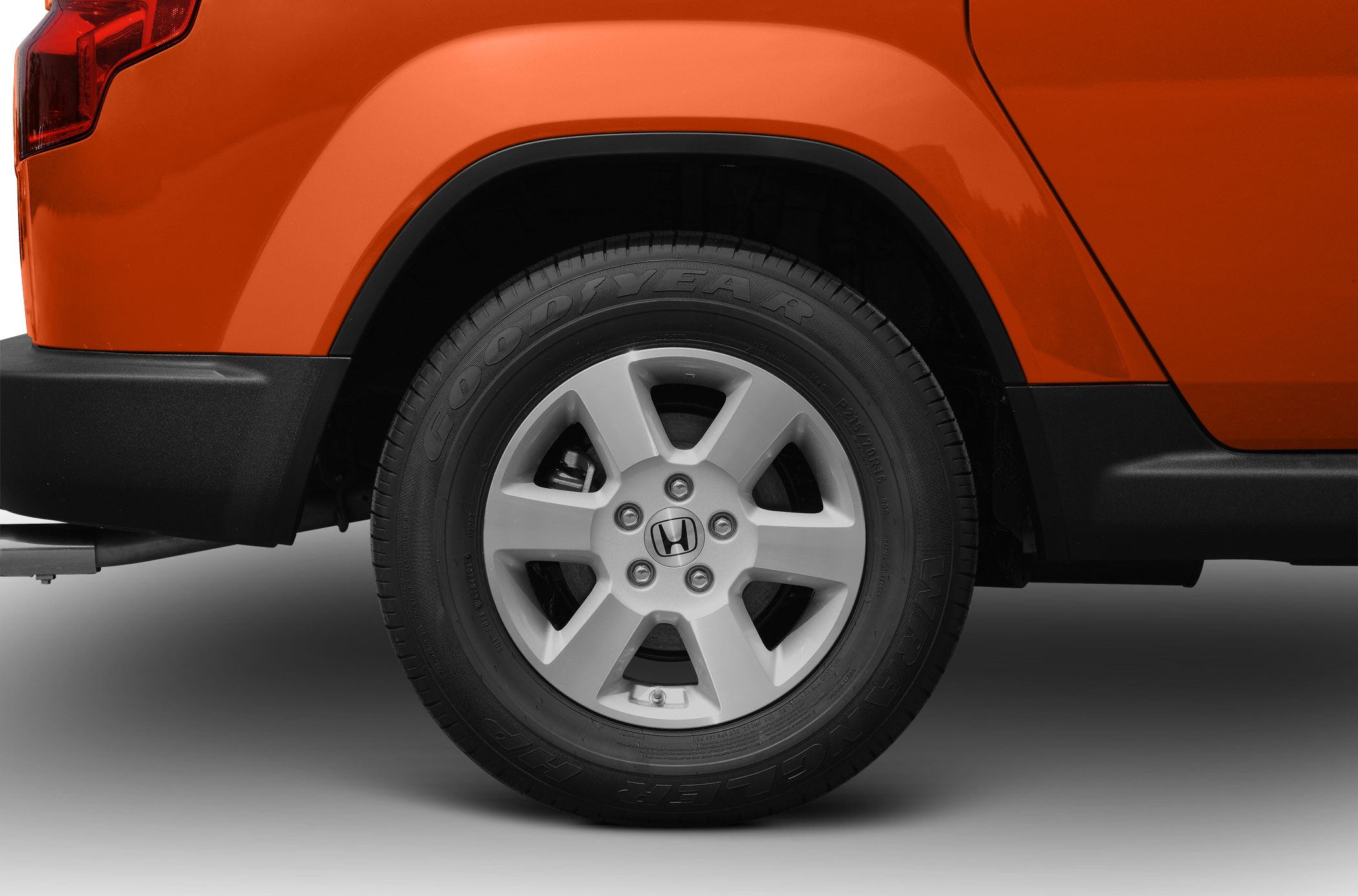 Close-up of alloy wheel and tire on orange vehicle rear side