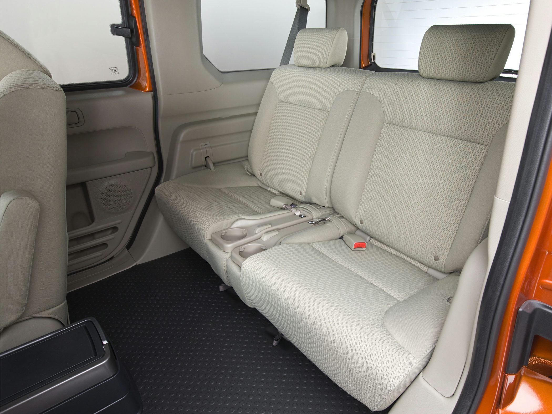 Beige rear seats with cup holders and textured upholstery.