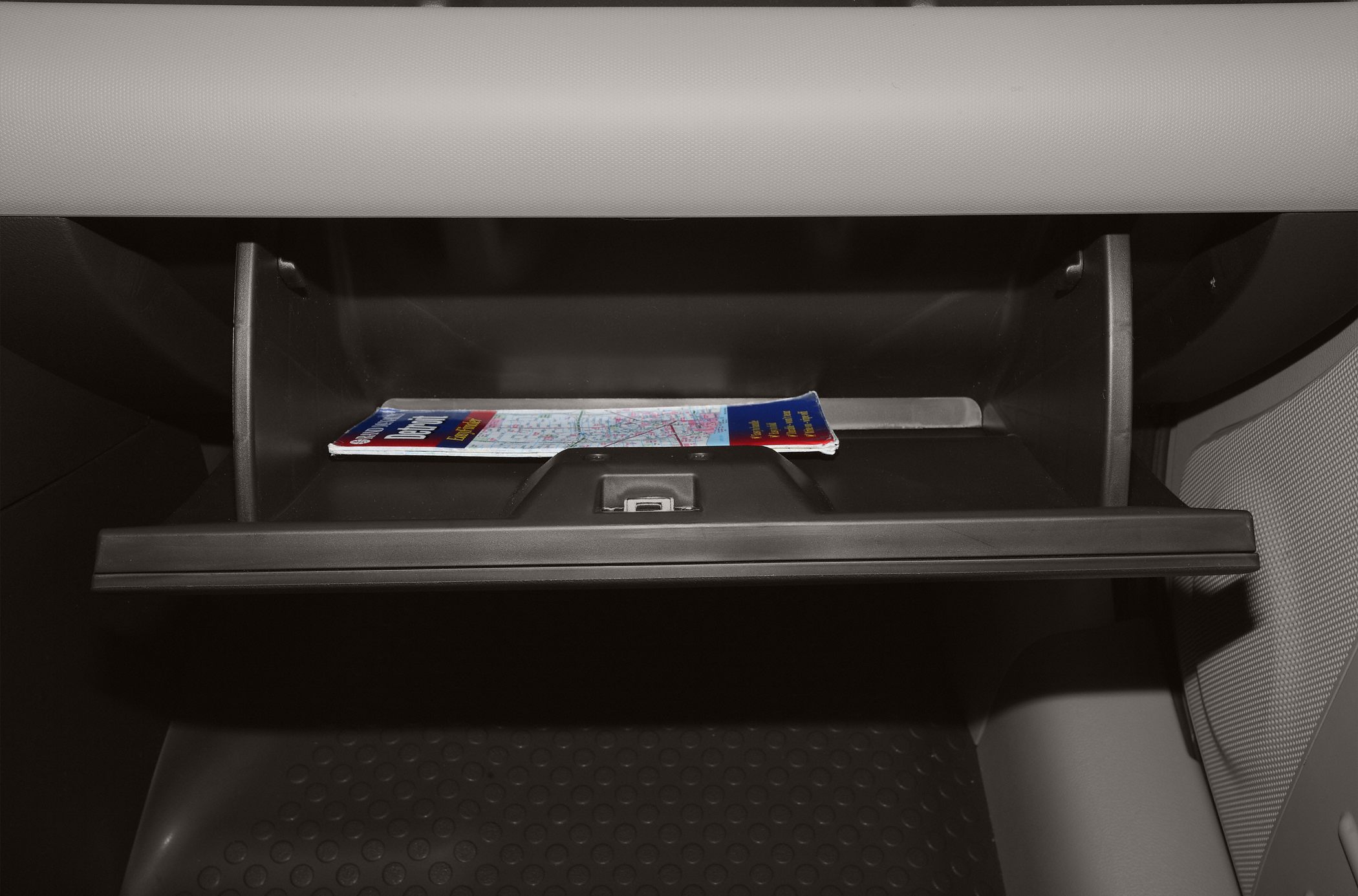 Open car glove box with a map inside