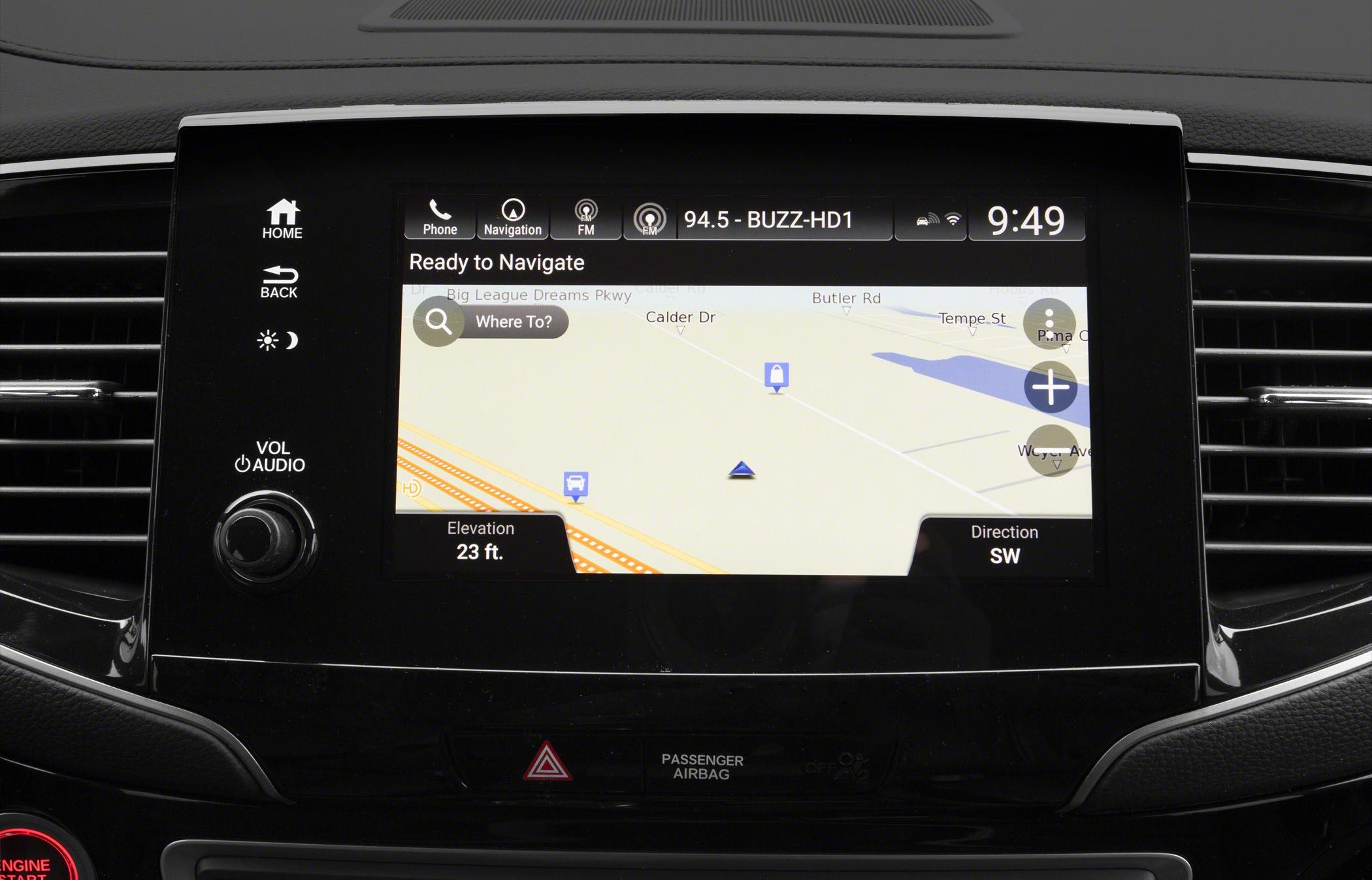 In-car navigation system with map, elevation, direction, controls, and audio knob.