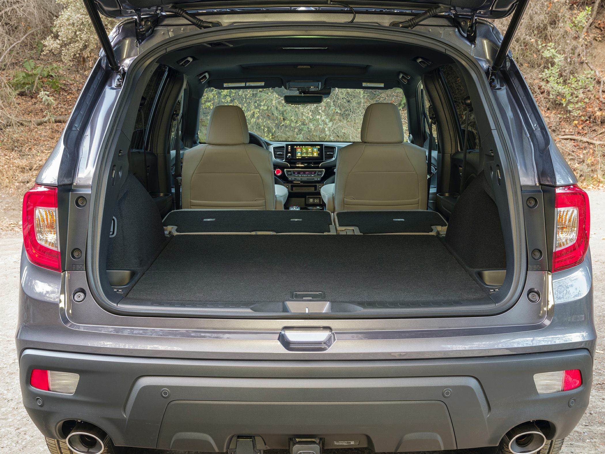 Spacious rear cargo area with folded rear seats and open hatch.