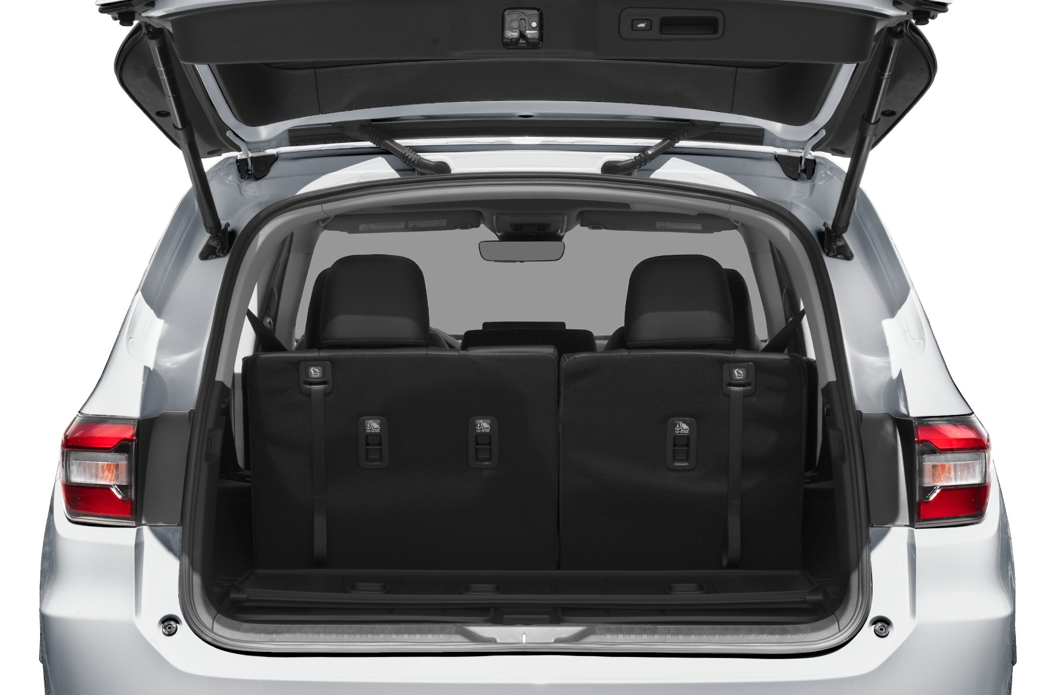 Spacious SUV rear cargo with upright third row seats and open tailgate.