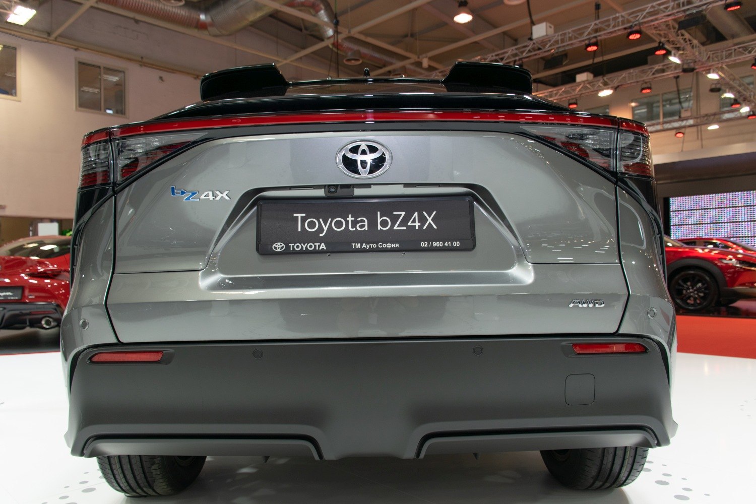 Rear view of an electric SUV featuring AWD badge and continuous taillight strip.