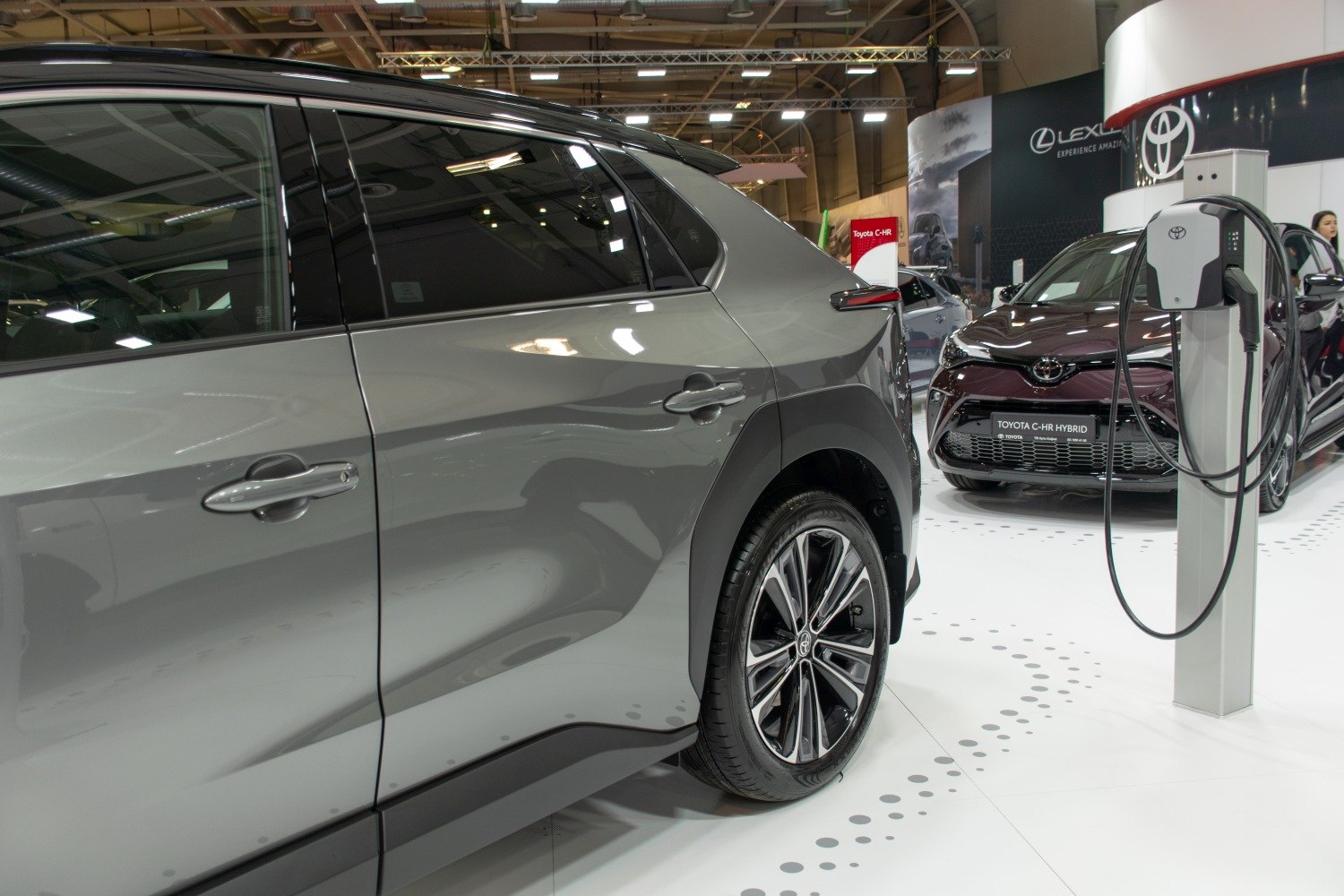 Rear side view of modern electric SUV with alloy wheels and charging station