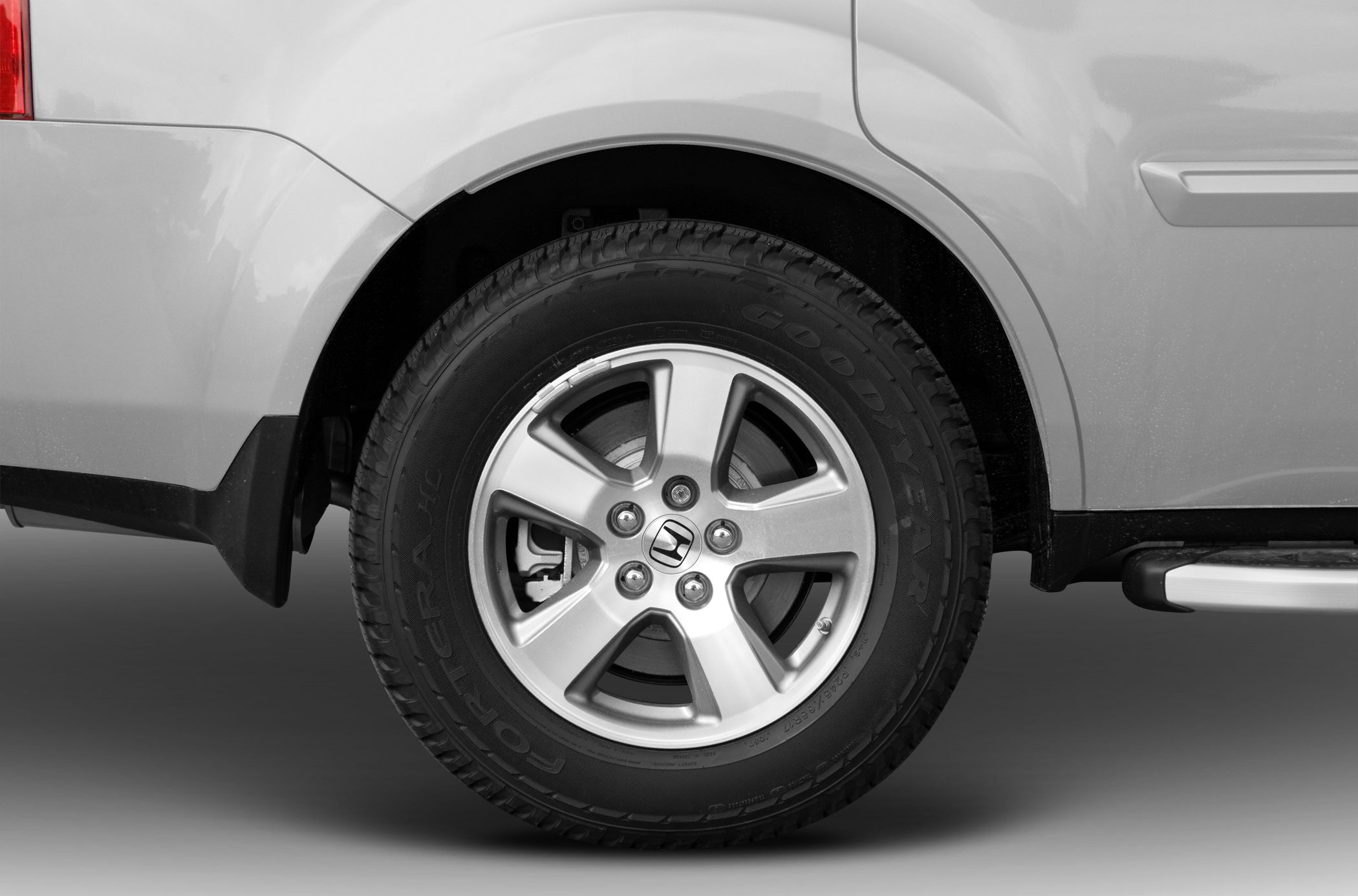 Close-up of alloy wheel and Goodyear tire on vehicle rear side.