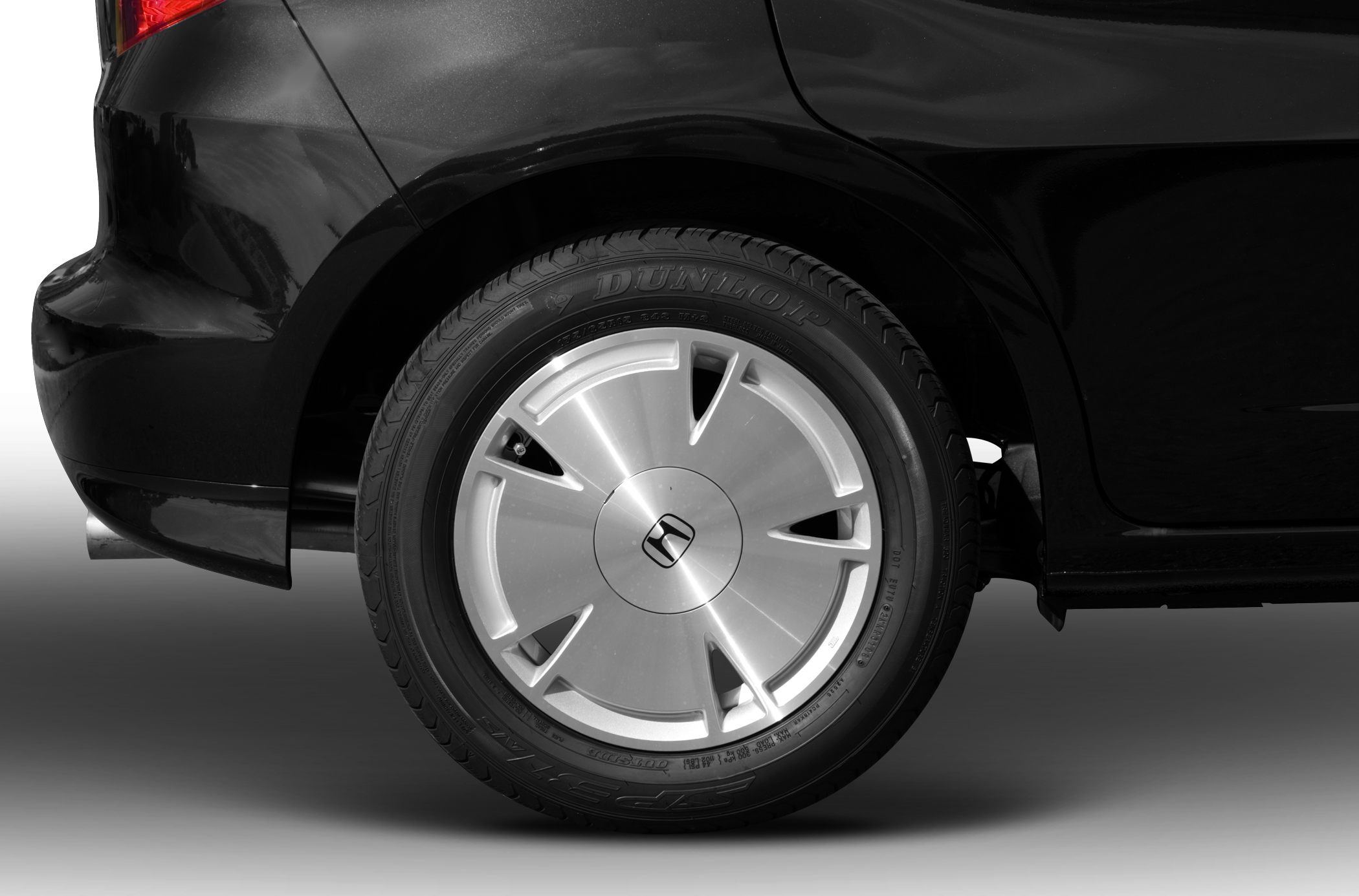 Close-up of a car's rear wheel, alloy rim, and tire tread