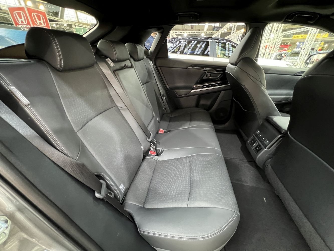Black leather rear seat interior with seatbelts and air vents.