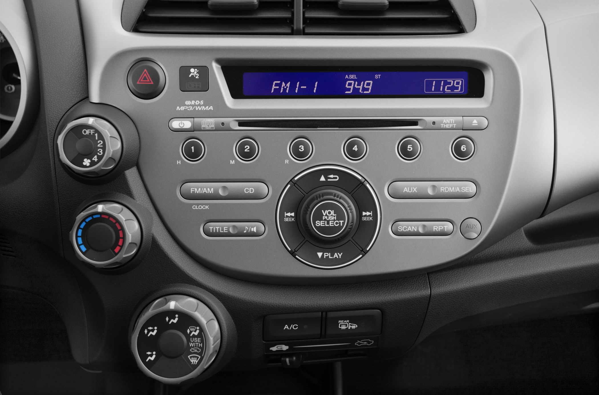 Car stereo and climate control panel with radio and temperature knobs.