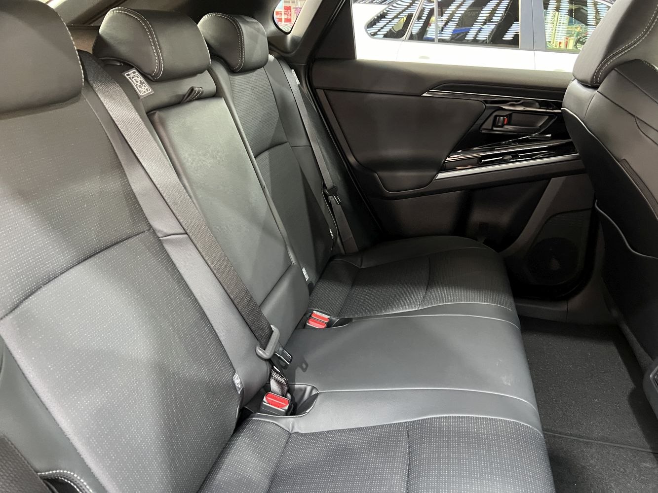 Black rear seat upholstery with seat belts and stitched headrests