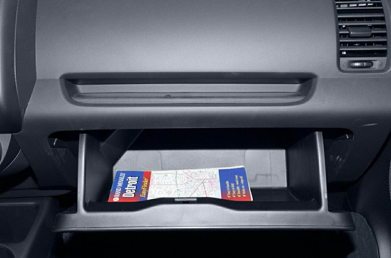 Open glove compartment with map inside car dashboard