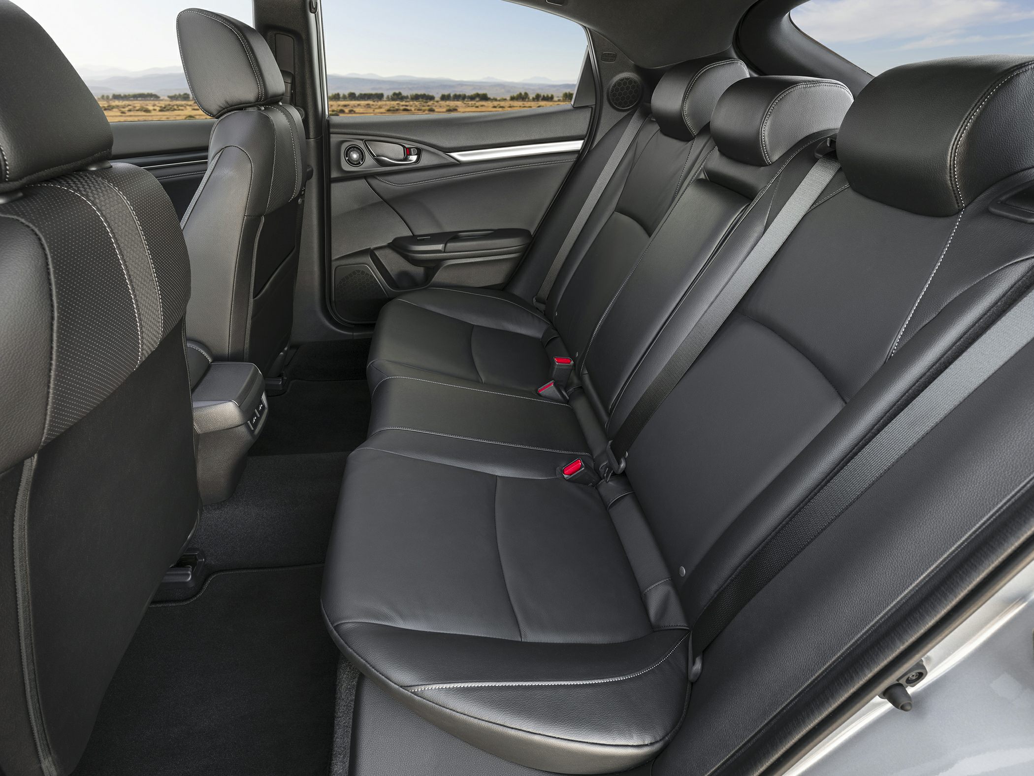 Rear black leather seats with seatbelts inside modern car interior