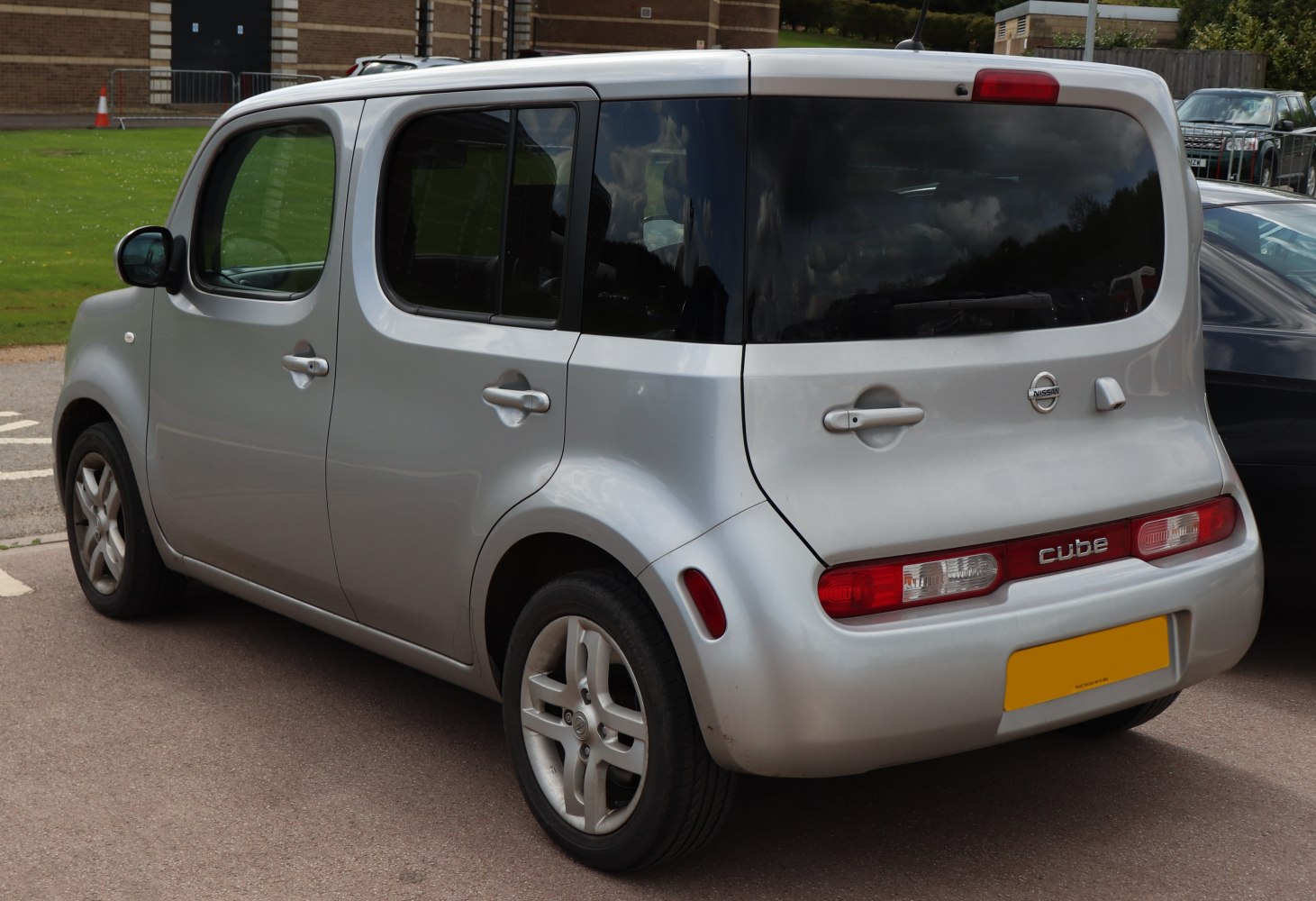 Boxy compact car rear and side with large windows and unique tail lights