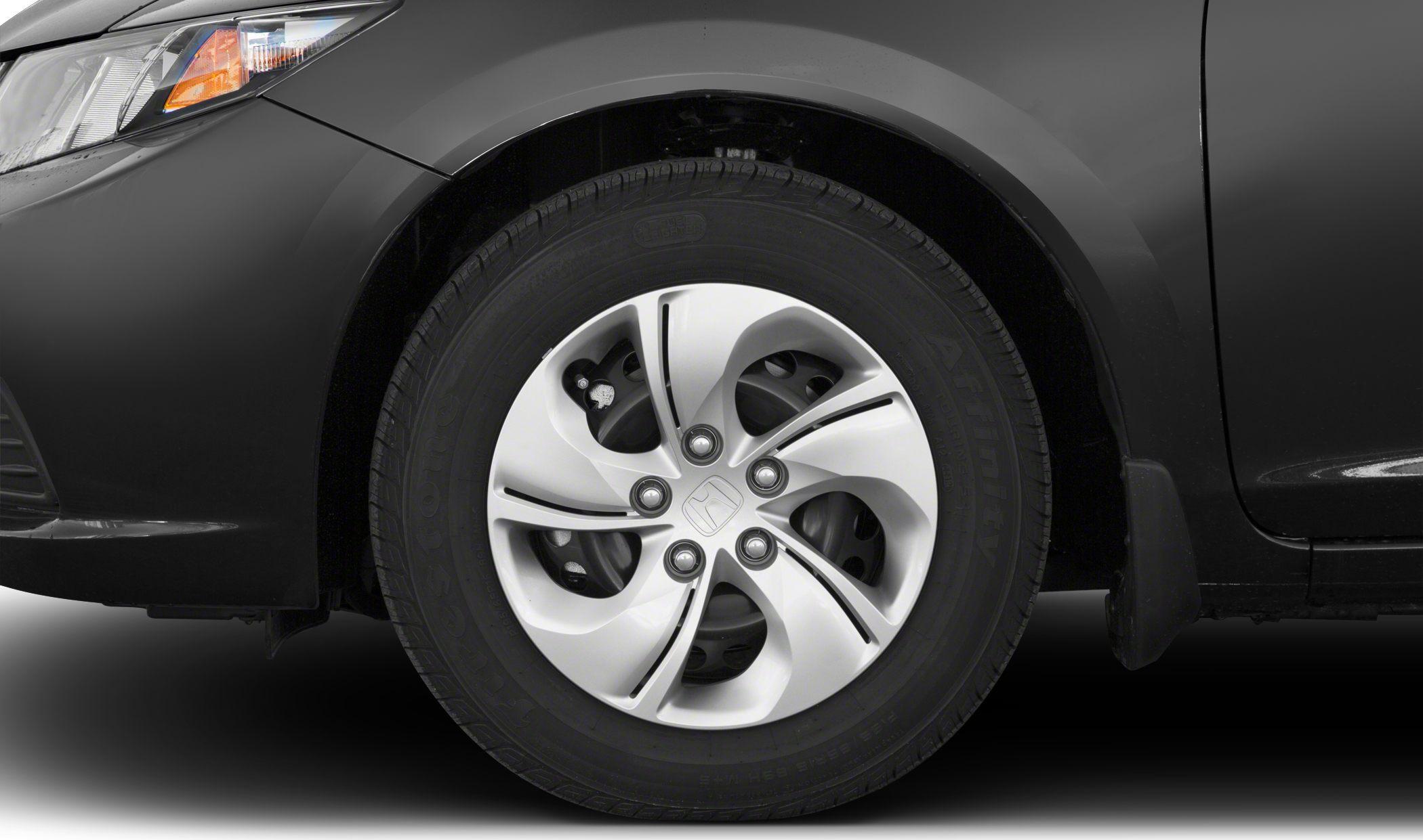 Close-up of alloy rim wheel with tire on a compact sedan.