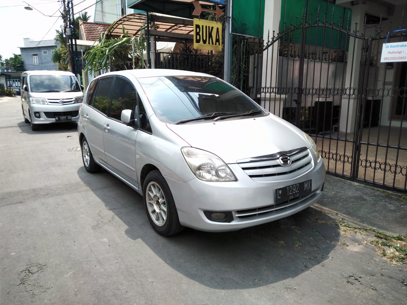 Front side view of silver compact MPV with alloy wheels and tinted windows